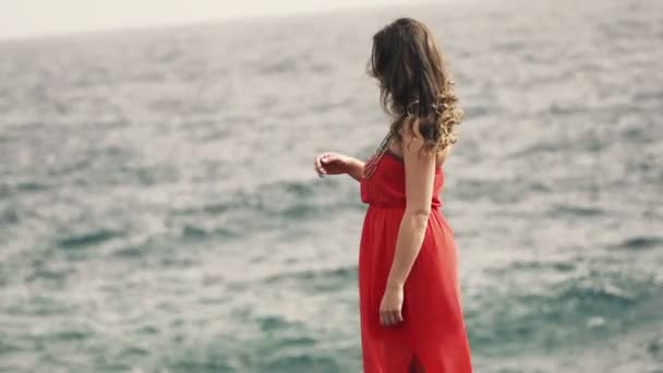 Ensam kvinna som står på klippor vid havet — Stockvideo