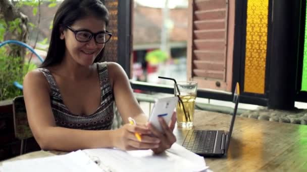 Porträtt av kvinna med smartphone i café i staden — Stockvideo