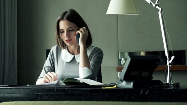 Femme d'affaires avec des documents parlant sur téléphone portable au bureau — Video