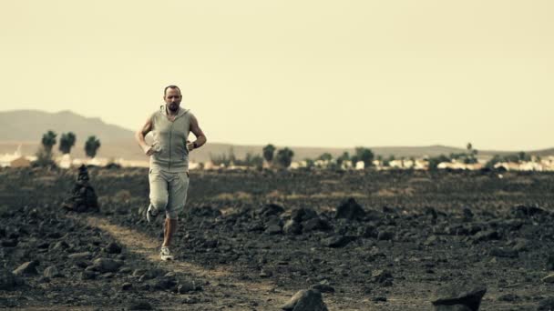 Young man jogging on desert — Stock Video