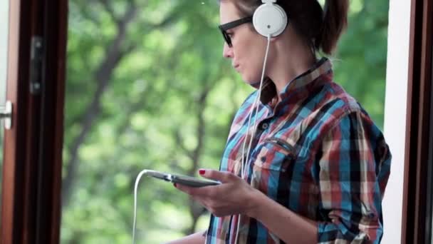 Vrouw luisteren naar muziek op mobiel op balkon — Stockvideo