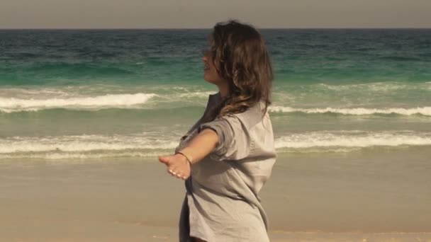 Жінка повертається навколо на пляжі — стокове відео