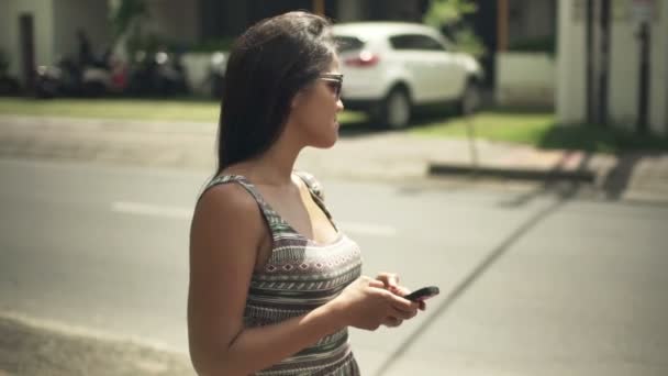 Mujer mensajes de texto en el teléfono inteligente en la ciudad — Vídeo de stock