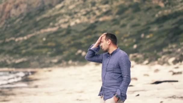 Verdrietig, nadenkend man die op strand — Stockvideo