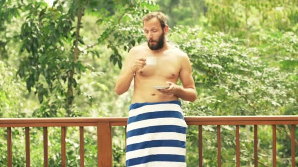 Homem sonolento em toalha bebendo café no terraço — Vídeo de Stock