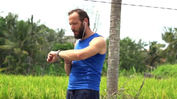 Homme jogging et vérification pouls sur smartwatch — Video