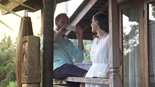 Mann fotografiert Freundin auf Terrasse — Stockvideo