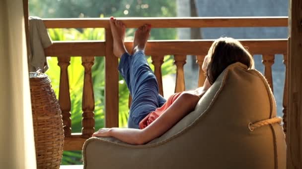 Junge Frau entspannt sich, sonnt sich auf der Terrasse — Stockvideo