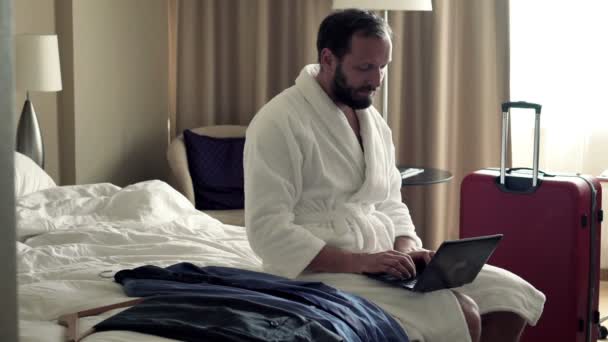 Businessman working on laptop sitting on bed — Stock Video