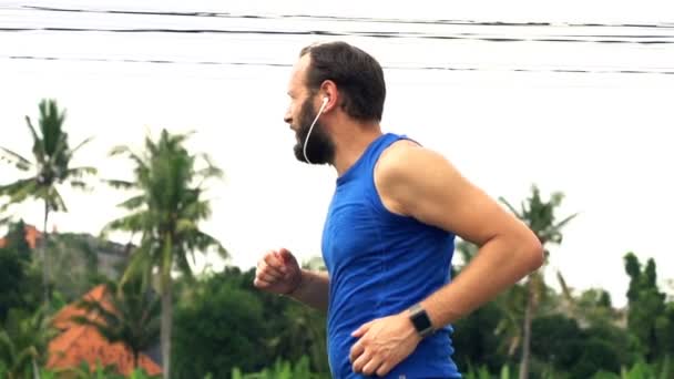 Giovane uomo che fa jogging in strada di campagna — Video Stock