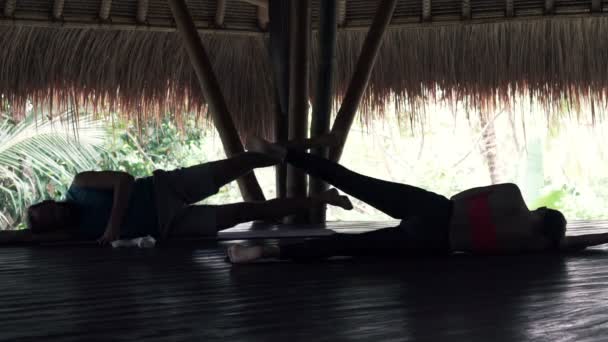 Пара делает упражнения на доске в деревянном сарае — стоковое видео
