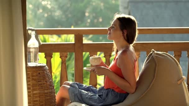 Vrouw koffie drinken en ontspannen op terras — Stockvideo