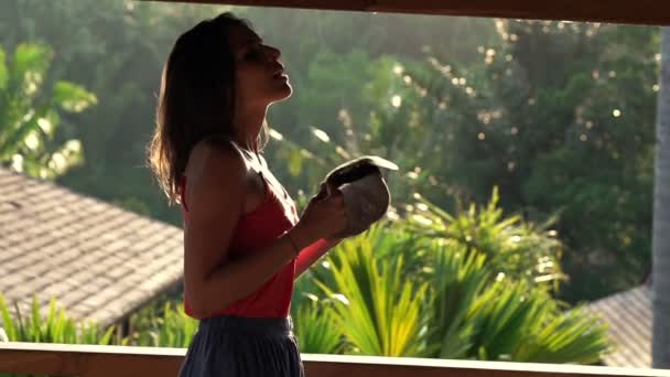 Жінка охолоджує себе капелюхом на терасі — стокове відео