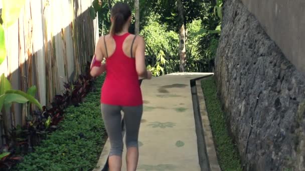 Junge Frau joggt im Park — Stockvideo