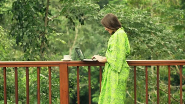 Woman using modern laptop and drinking coffee — Stock Video