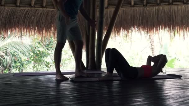 Woman doing crunches with personal trainer — Stock Video