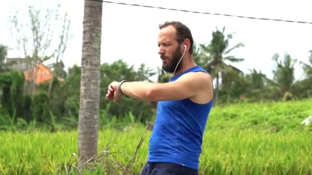 Homme jogging et vérification pouls sur smartwatch — Video