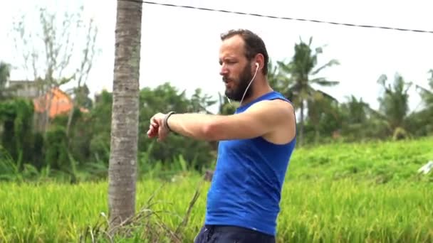 Hombre trotando y comprobando el pulso en smartwatch — Vídeo de stock