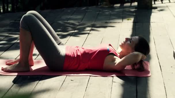 Vrouw uit te oefenen, doen crunches op mat op terras — Stockvideo