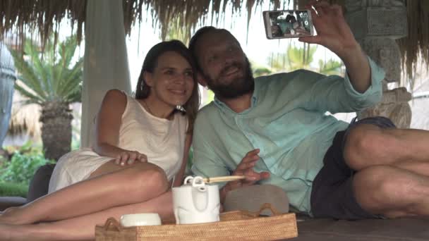 Couple prenant selfie photo avec téléphone portable sur un lit gazebo — Video