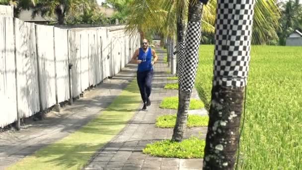 Young man jogging on path in country — Stock Video