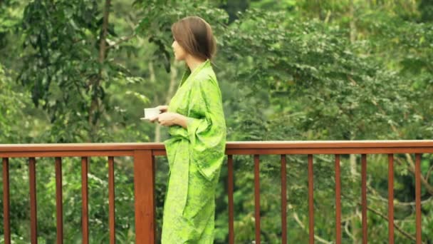 Woman drinking coffee by table in kitchen — Stock Video