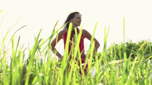 Woman looking around standing in grass — Stock Video