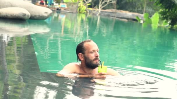 Homem beber coquetel na piscina — Vídeo de Stock