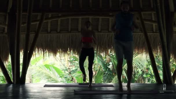 Пара біжить на килимку в дерев'яному сараї — стокове відео