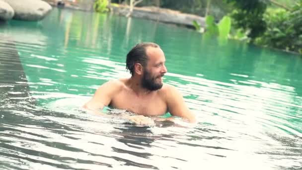 Счастливый человек отдыхает в бассейне — стоковое видео