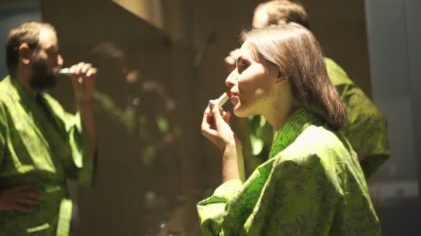 Vrouw toepassen van lippenstift en man tandenpoetsen — Stockvideo