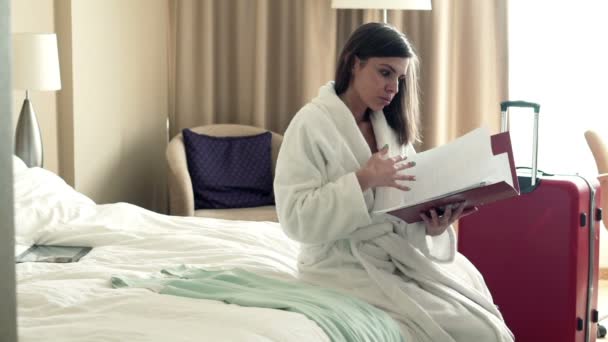 Sad businesswoman working with documents on bed — Stock Video