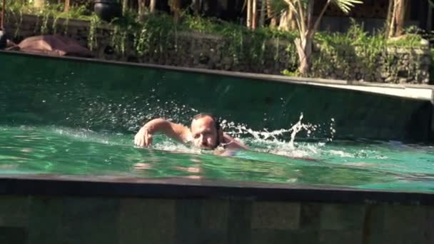 Young man swimming into pool — Stock Video