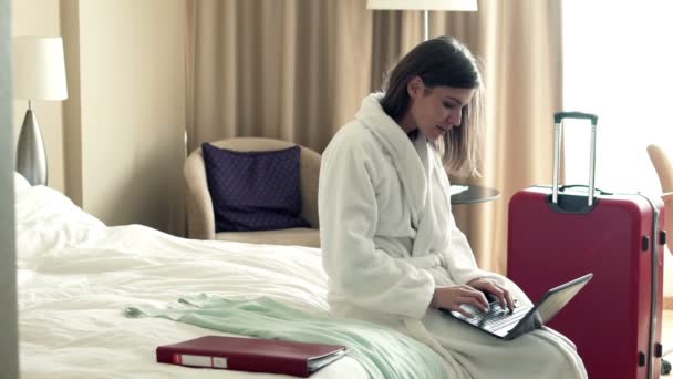 Businesswoman working on laptop sitting on bed — Stock Video