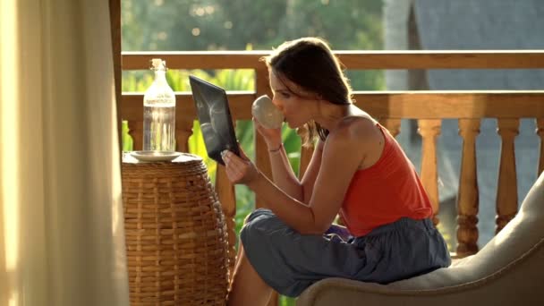 Femme lisant quelque chose sur tablette et buvant du café — Video