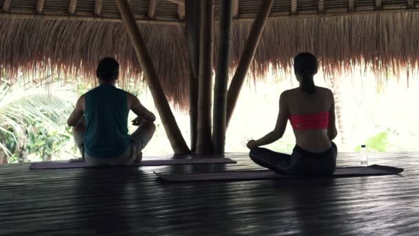 Pareja meditando en estera en granero de madera — Vídeo de stock