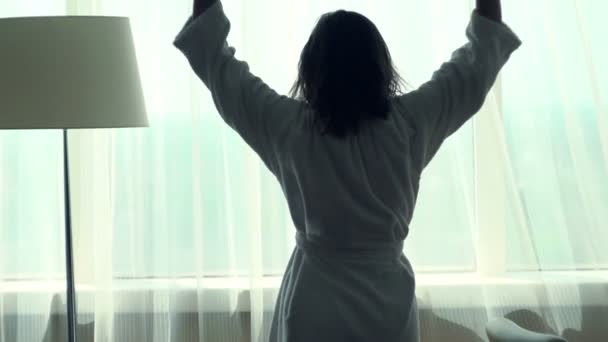 Mujer estirando los brazos y desvelando cortinas — Vídeo de stock