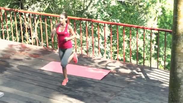 Mulher fazendo aquecimento, correndo no terraço — Vídeo de Stock