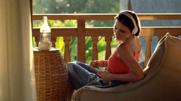 Junge Frau hört Musik auf Terrasse — Stockvideo