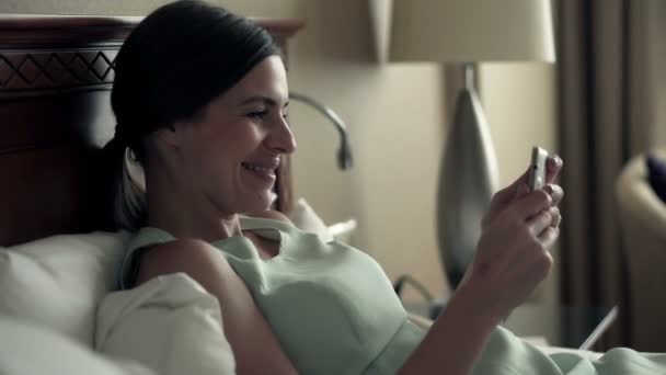 Бізнес-леді дивиться фільм на смартфон в готельному номері — стокове відео