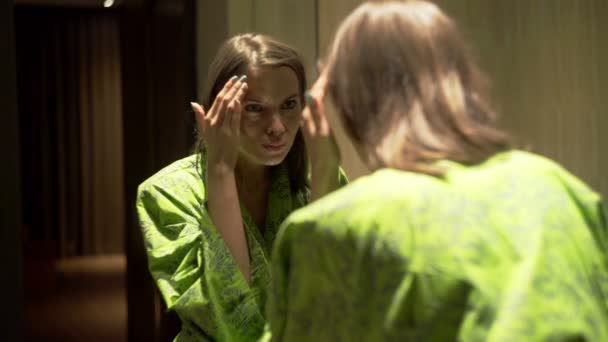Mujer revisando su cara en busca de arrugas en el baño — Vídeos de Stock