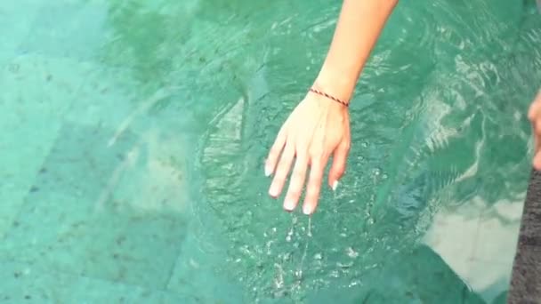 Weibliche Hand spielt mit Wasser im Schwimmbad — Stockvideo