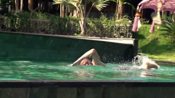 Hombre joven nadando en la piscina — Vídeos de Stock