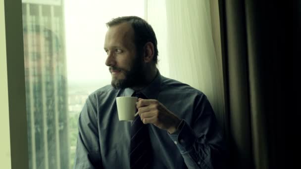 Επιχειρηματίας πίνοντας καφέ συνεδρίαση από το παράθυρο — Αρχείο Βίντεο