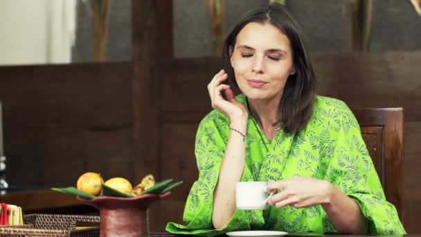 Kobieta pije kawę przy stole w kuchni — Wideo stockowe