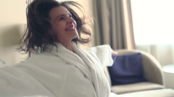 Woman in bathrobe falling on bed — Stock Video