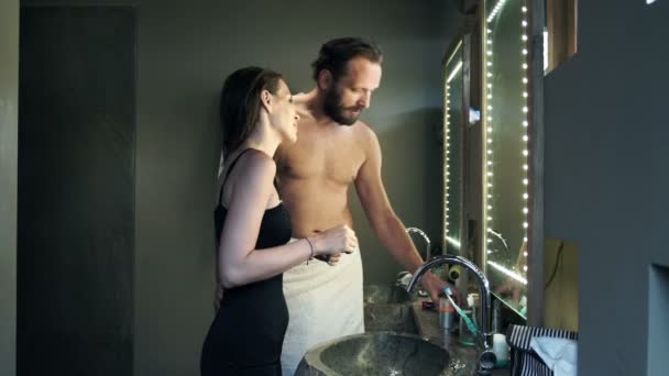 Пара разговаривает во время утренней рутины в ванной комнате — стоковое видео