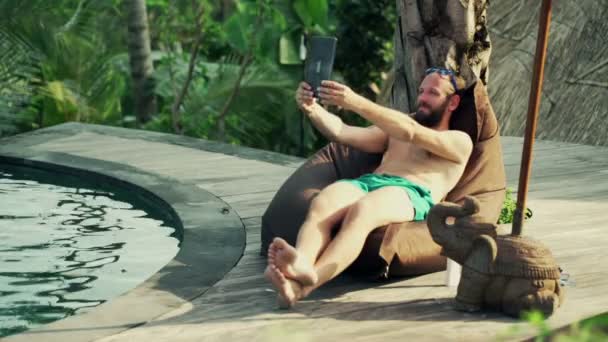 Hombre tomando foto selfie con la tableta junto a la piscina — Vídeo de stock