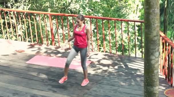Женщина упражняется, вытягивая ноги и руки — стоковое видео