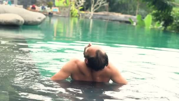 Un tânăr se relaxează în piscină — Videoclip de stoc